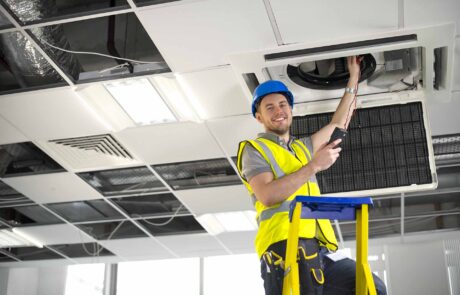 electrician fitting air conditioning to office interior